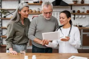 Doctor discussing tablet information with couple.